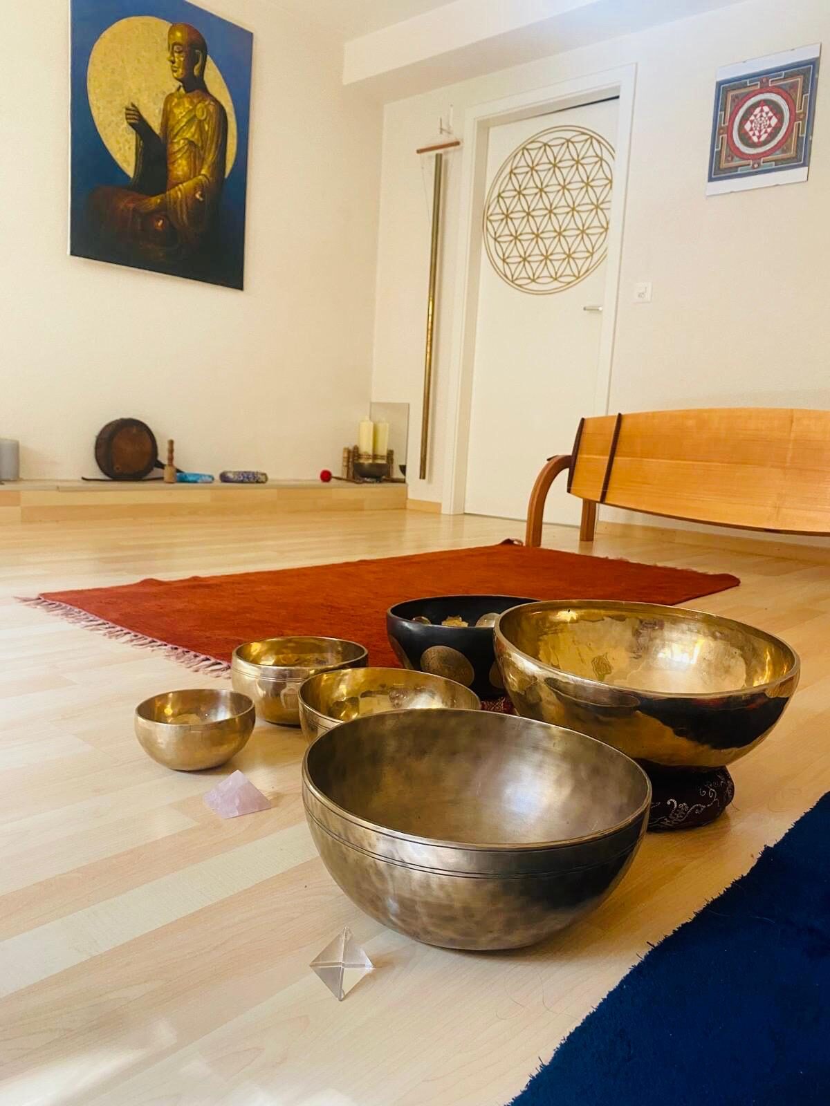 Bols chantants posés au soleil sur le parquet, utilisés en méditation sonore à Mies